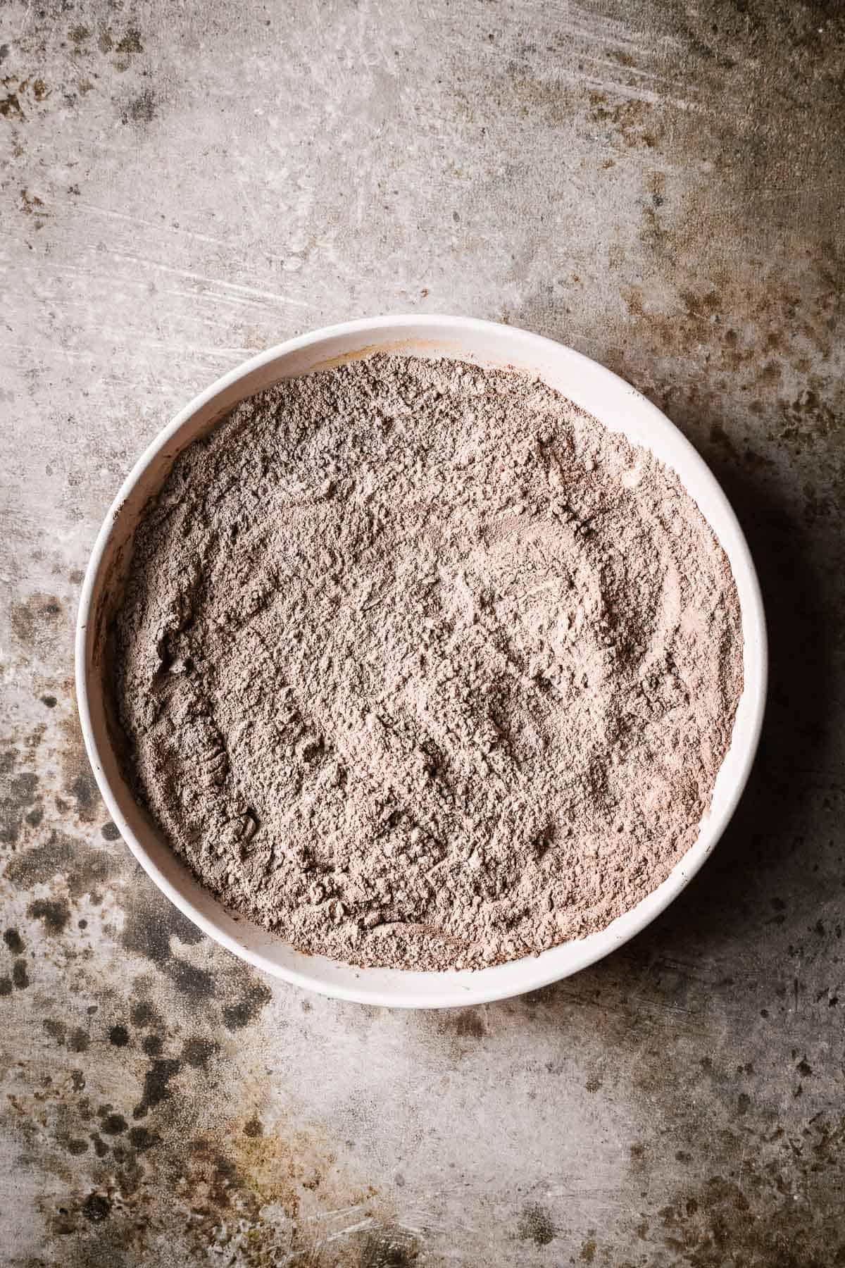 Dry ingredients for a cake mixed together in a shallow bowl.