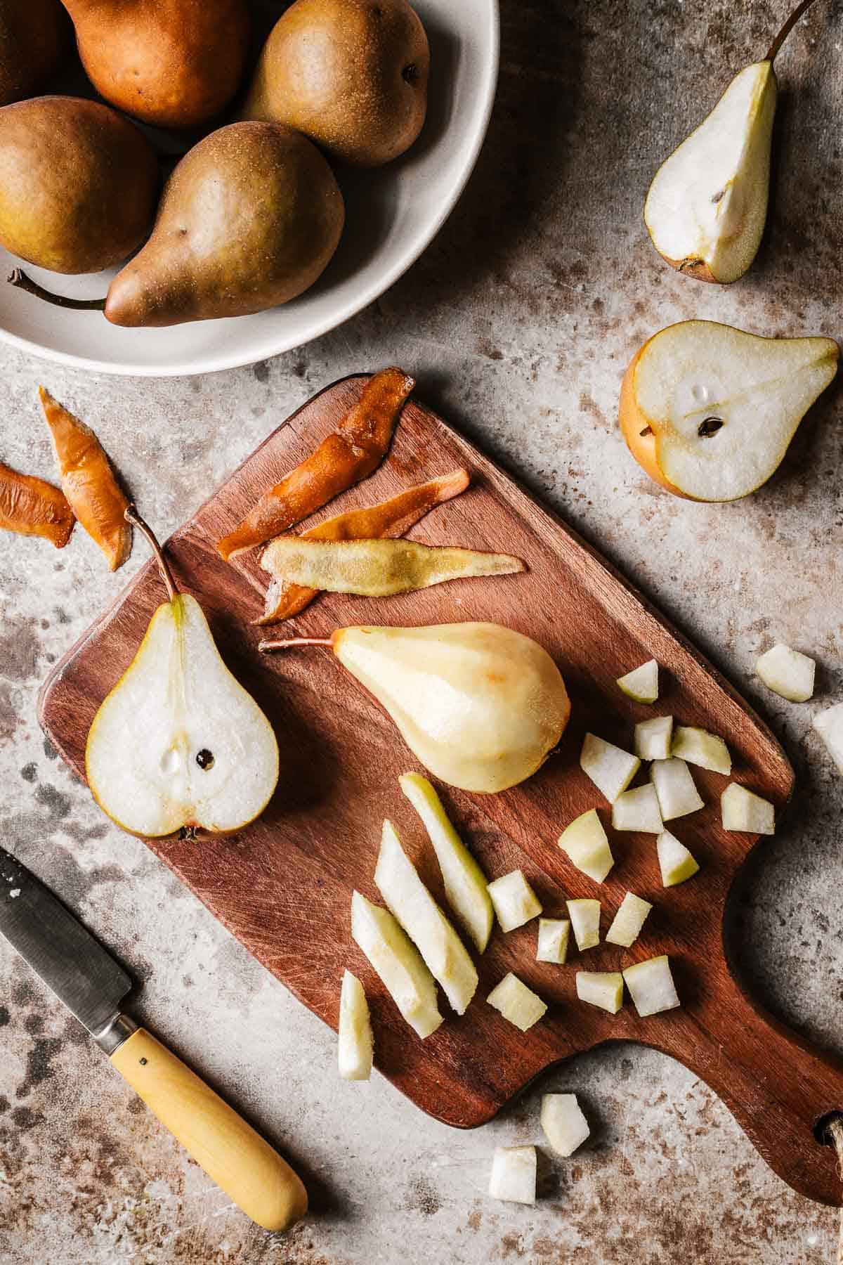 Pears being diced on a wooden cutting board.