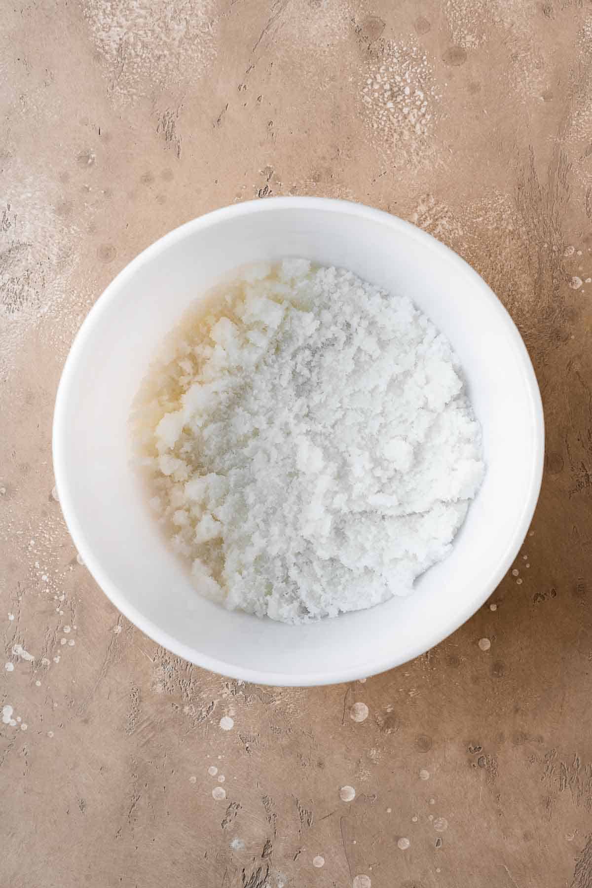 Sugar and oil in a white mixing bowl.