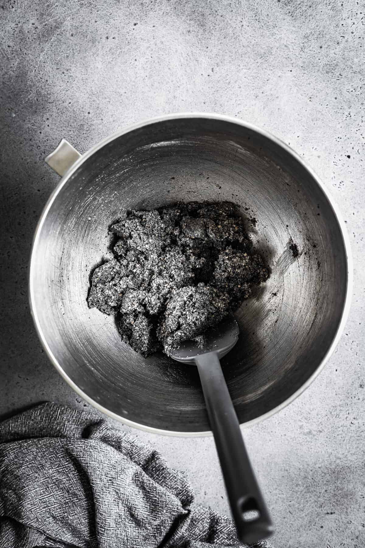 A mixing bowl with butter, sugar and ground black sesame seeds mixed together.