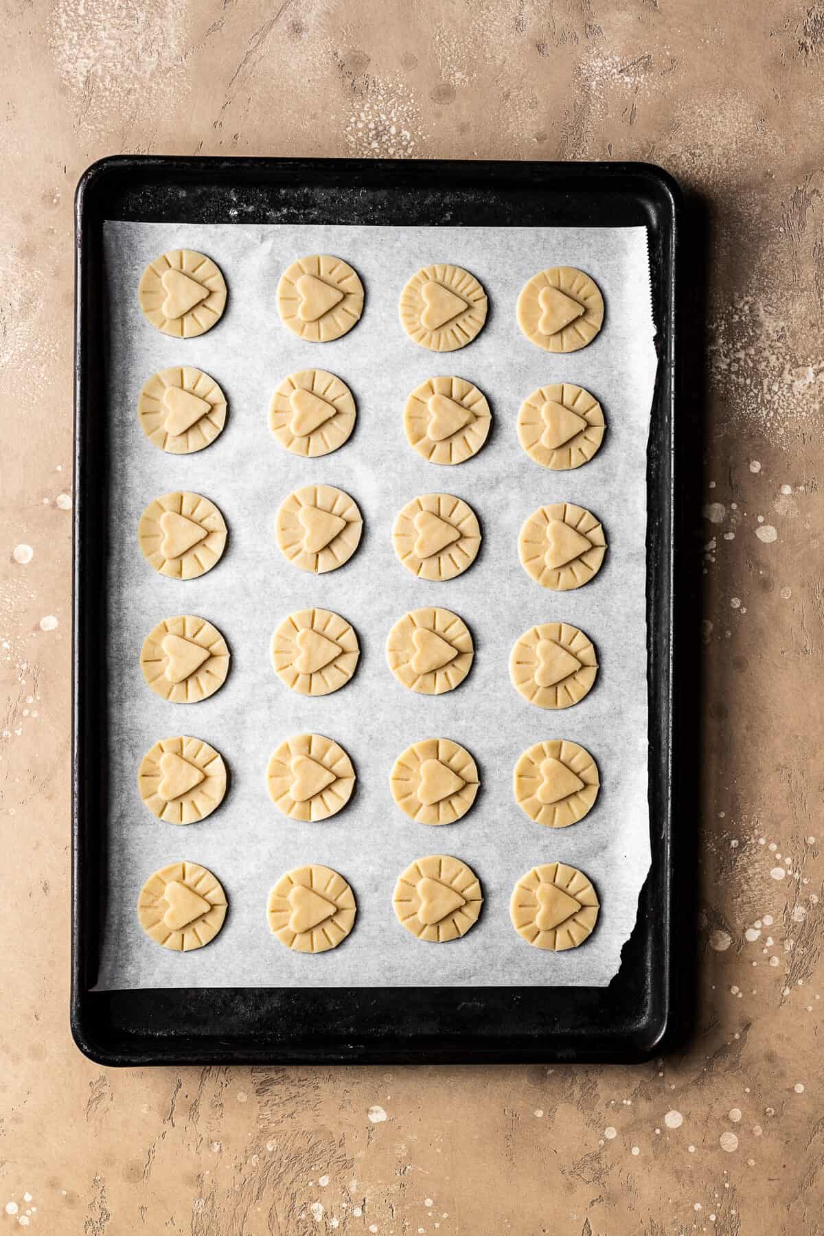 Unbaked dough circles with hearts on top for nutella biscuits.