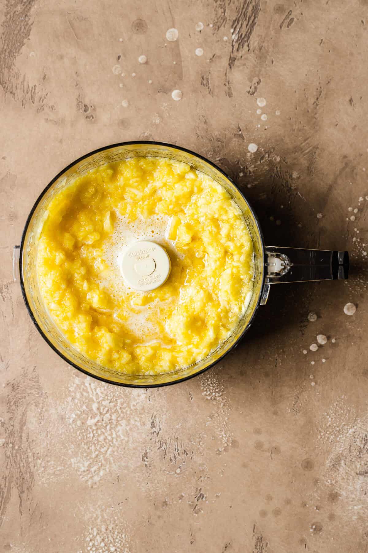 Fresh pineapple pureed in a food processor.