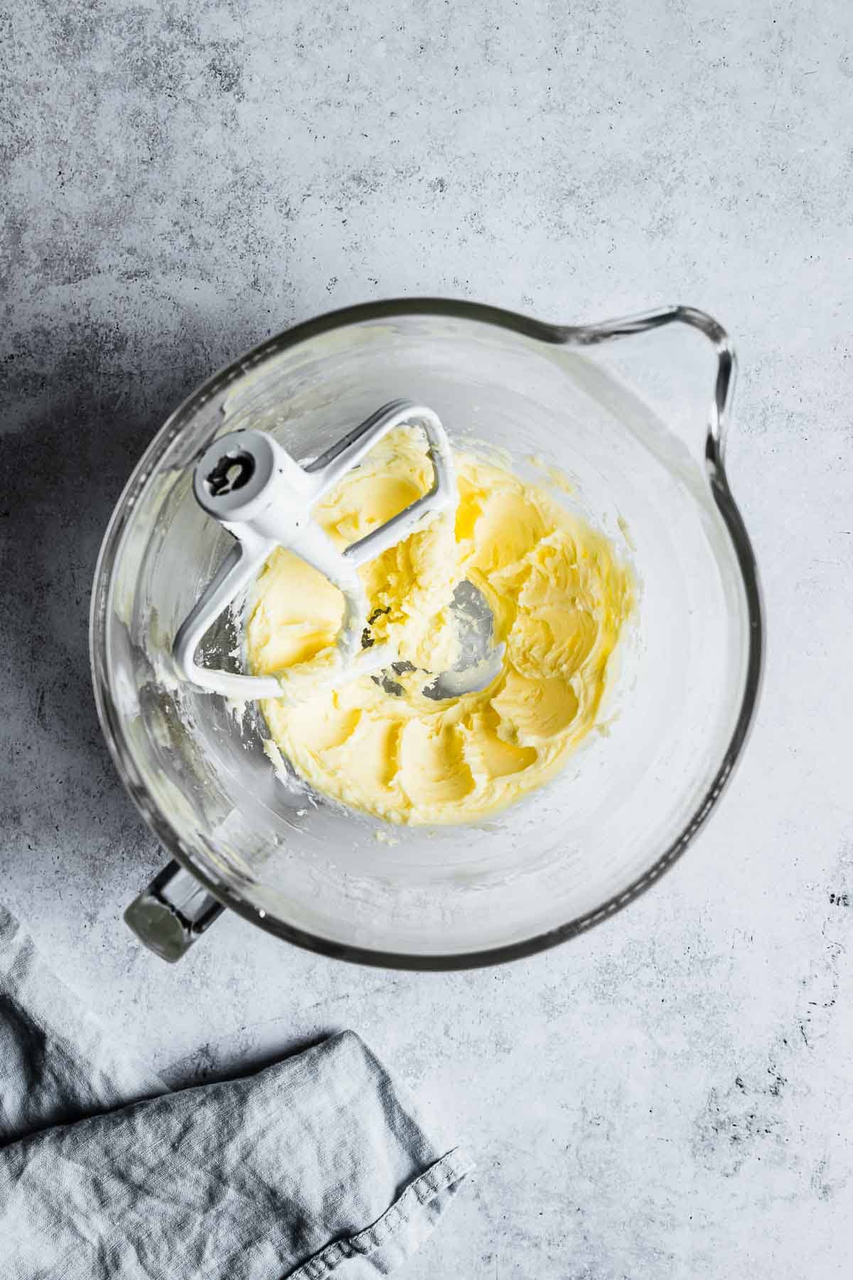 A mixing bowl with creamed butter and sugar.