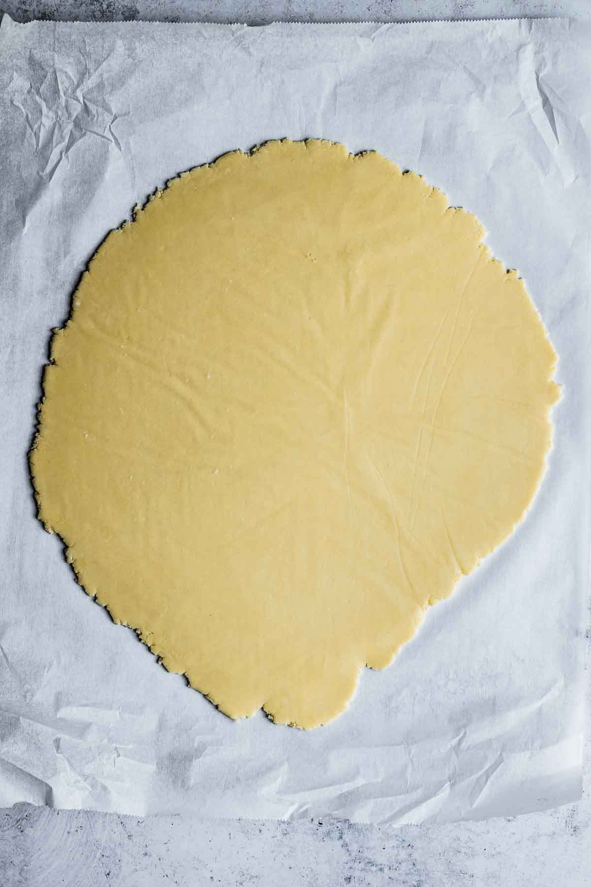 Rolled cookie dough on white parchment paper.