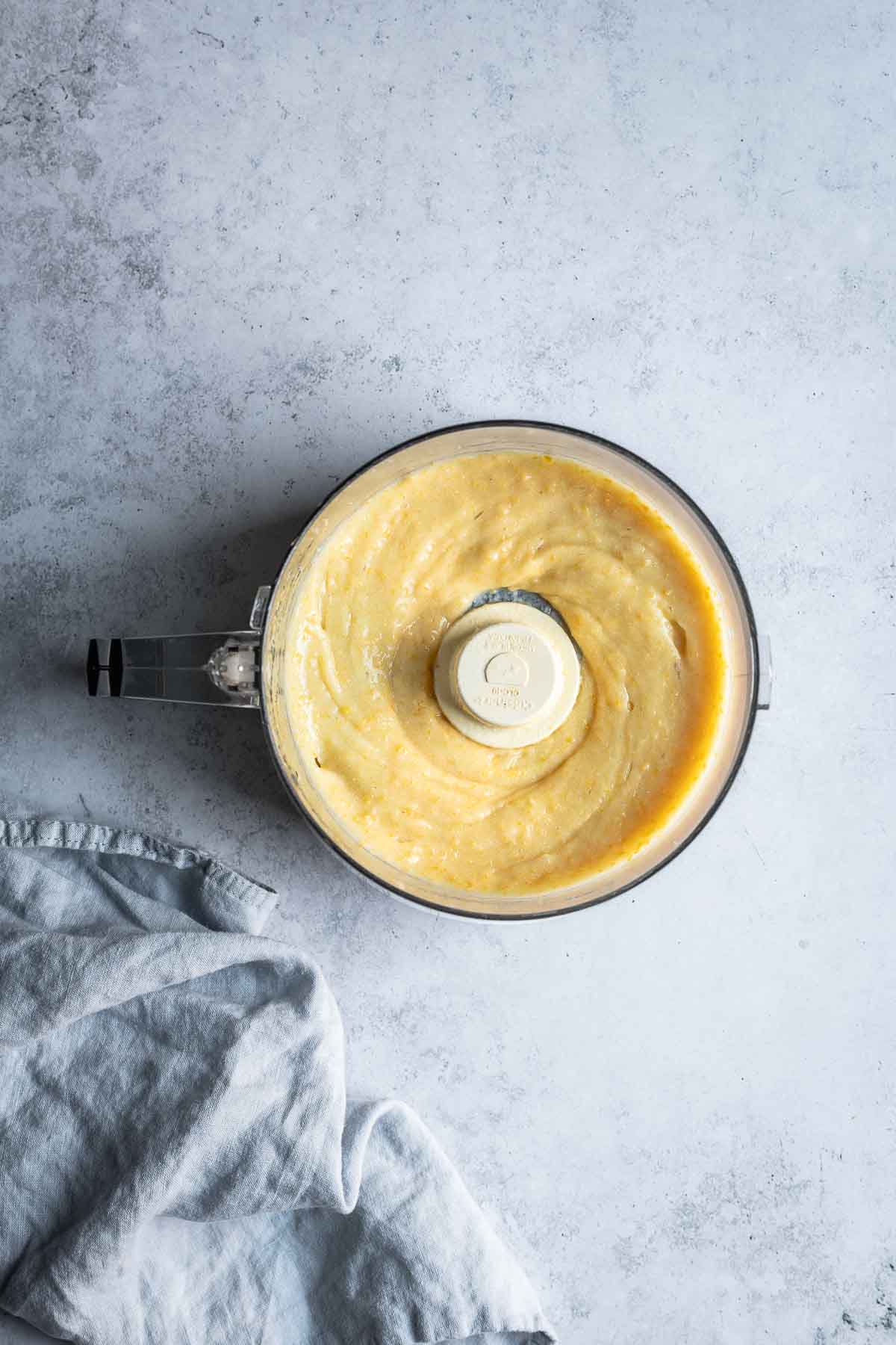 A food processor with a puree of whole lemons inside.