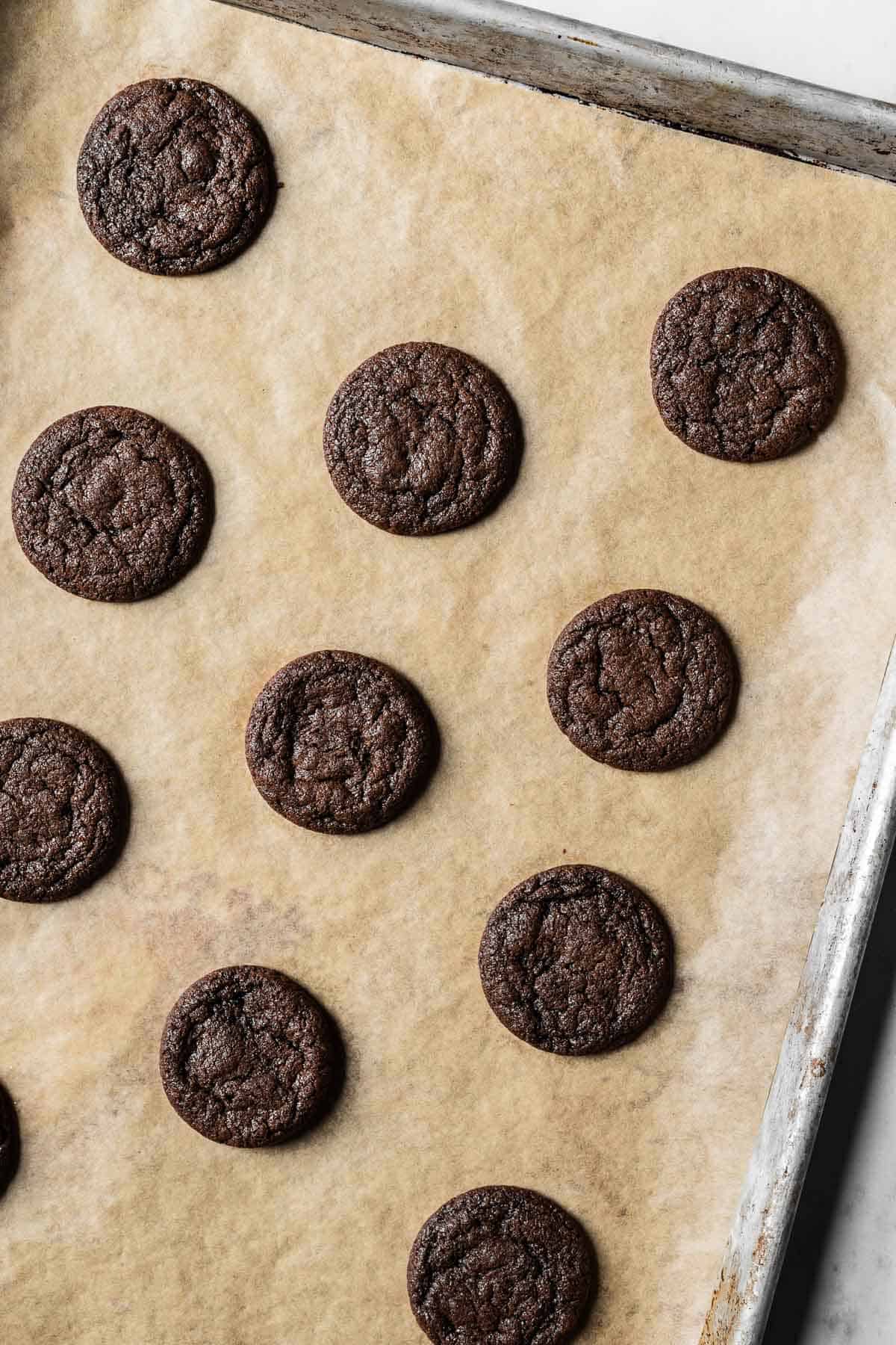 Baked chocolate mascarpone cookies on a parchment lined baking sheet.