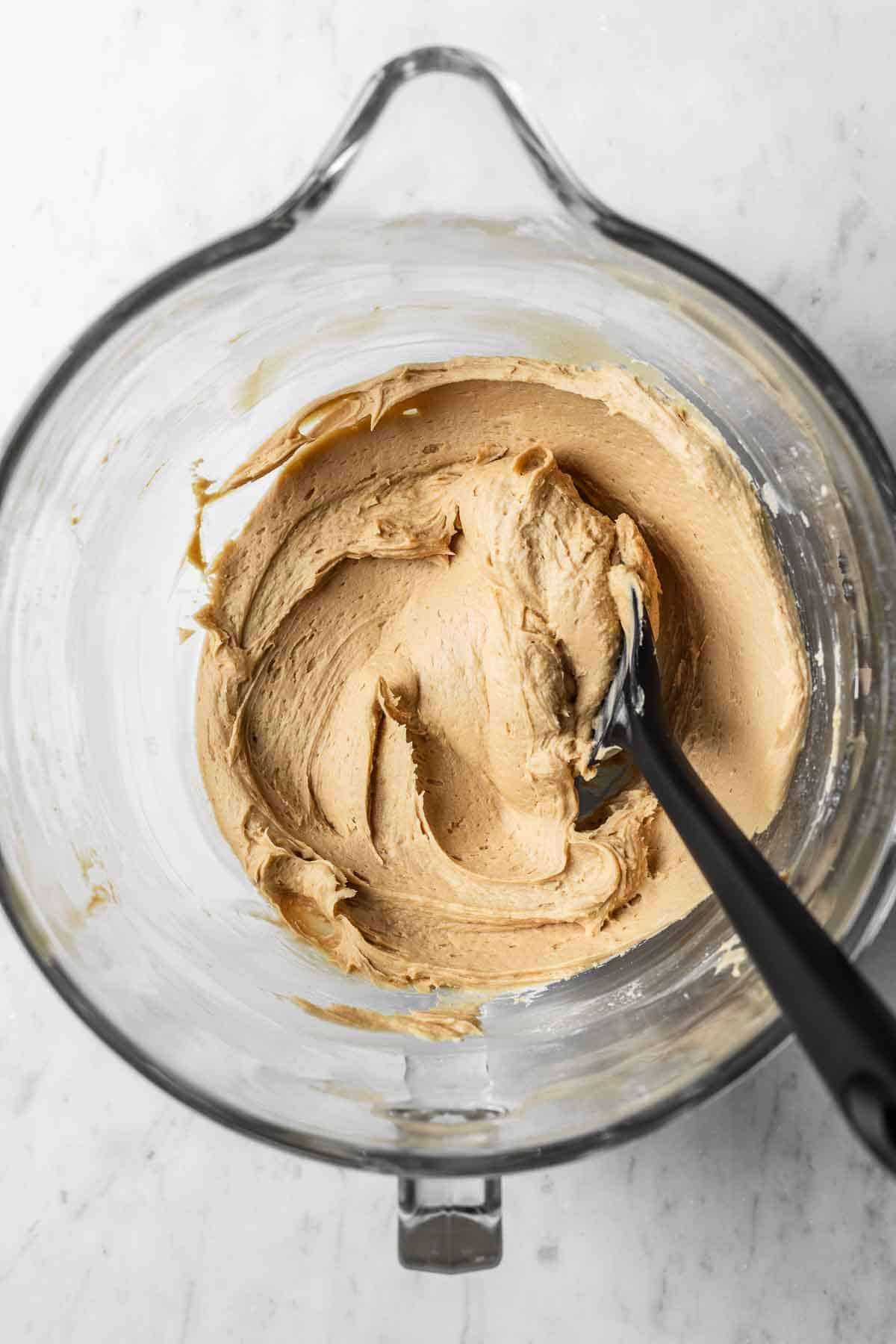 Espresso mascarpone frosting in a glass mixing bowl.