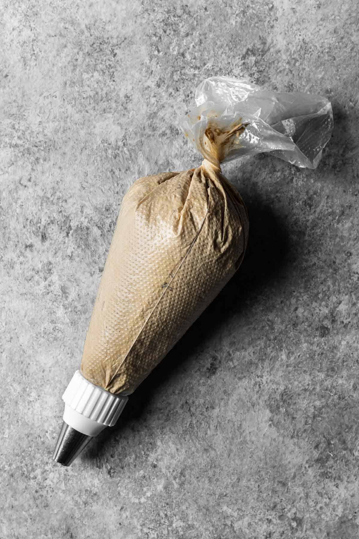 A 16 inch piping bag with a round tip filled with coffee mascarpone topping.