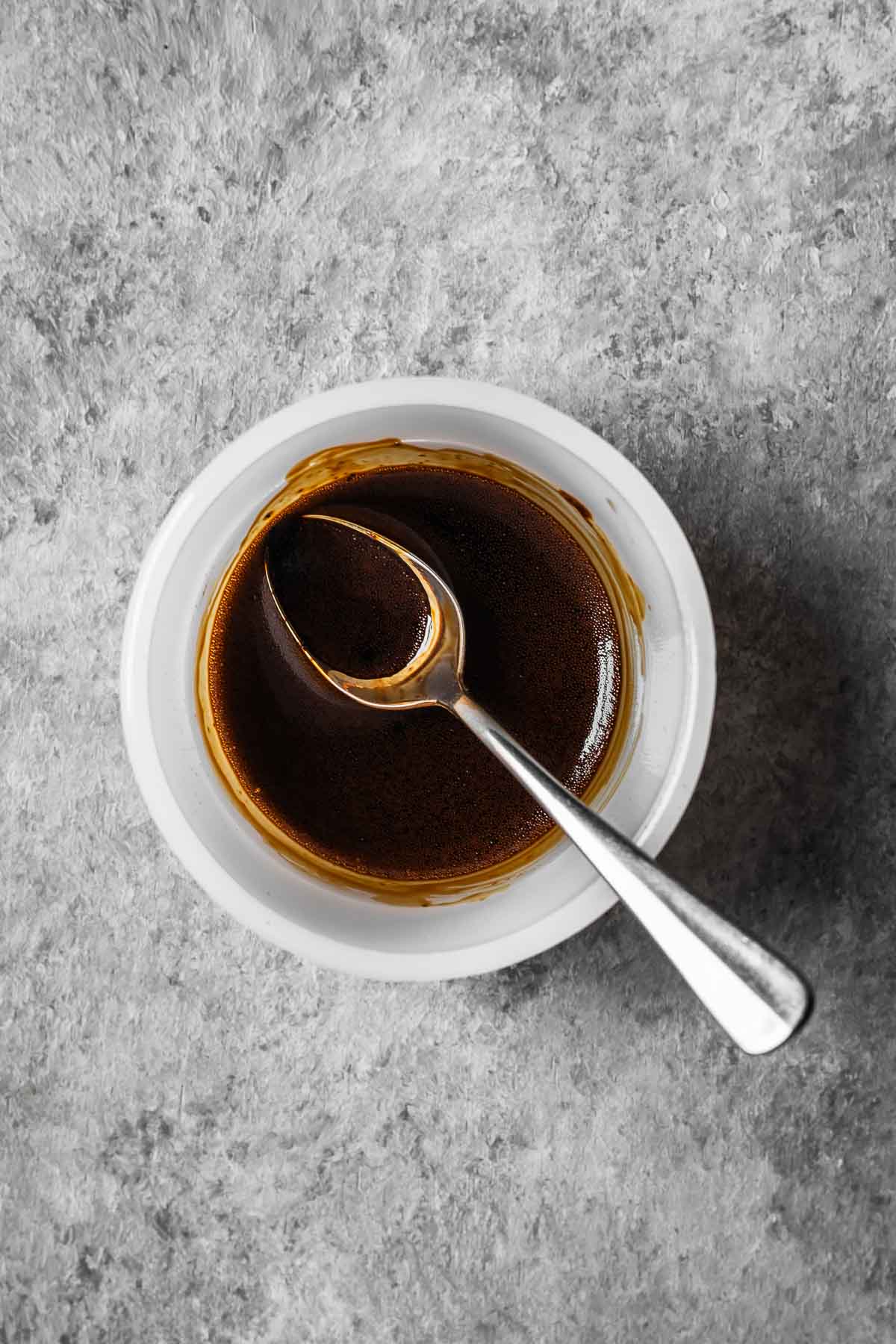 Espresso powder and vanilla extract mixed into a slurry in a small bowl.