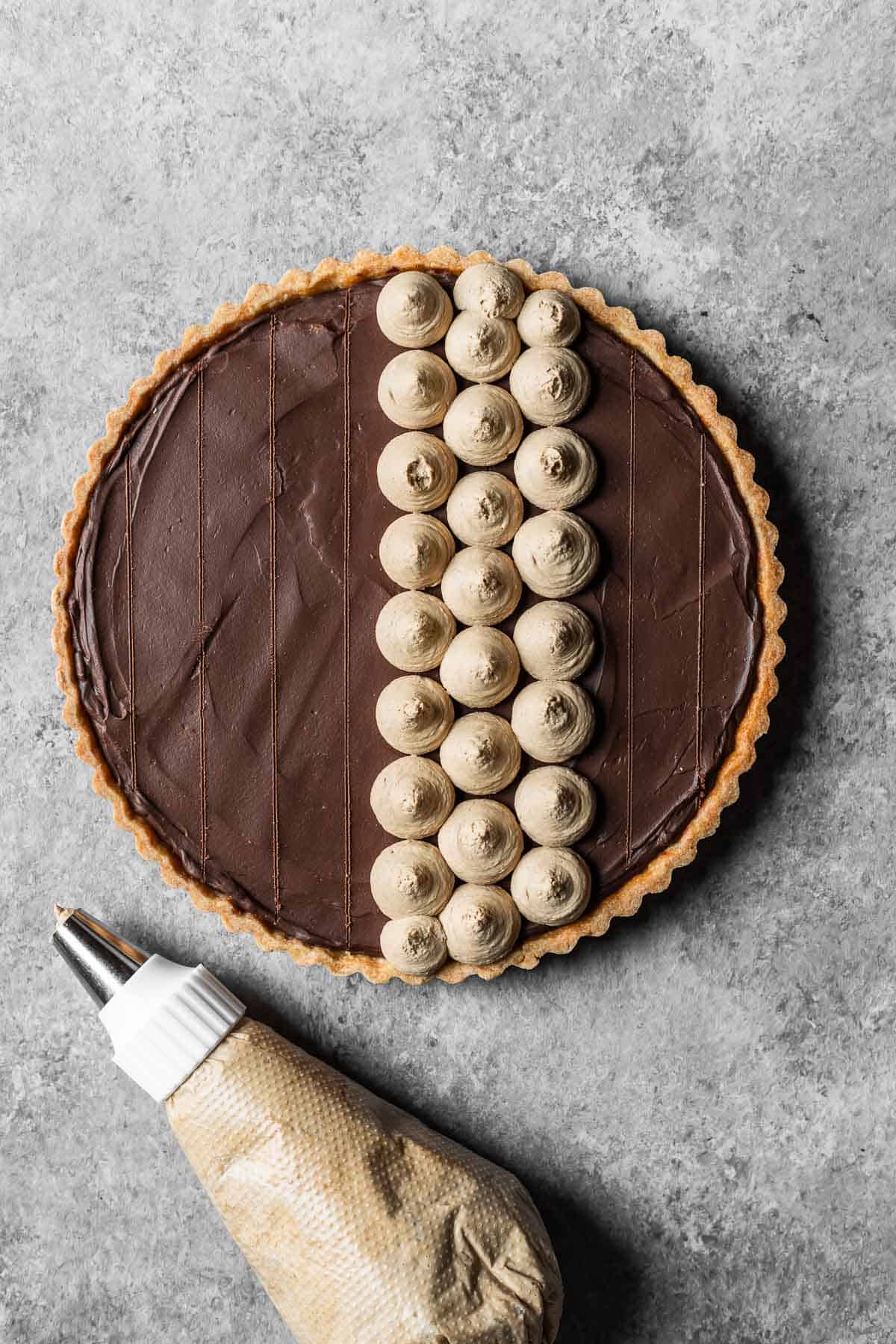 A chocolate ganache tart with guidelines marked for piping circles of coffee mascarpone topping.