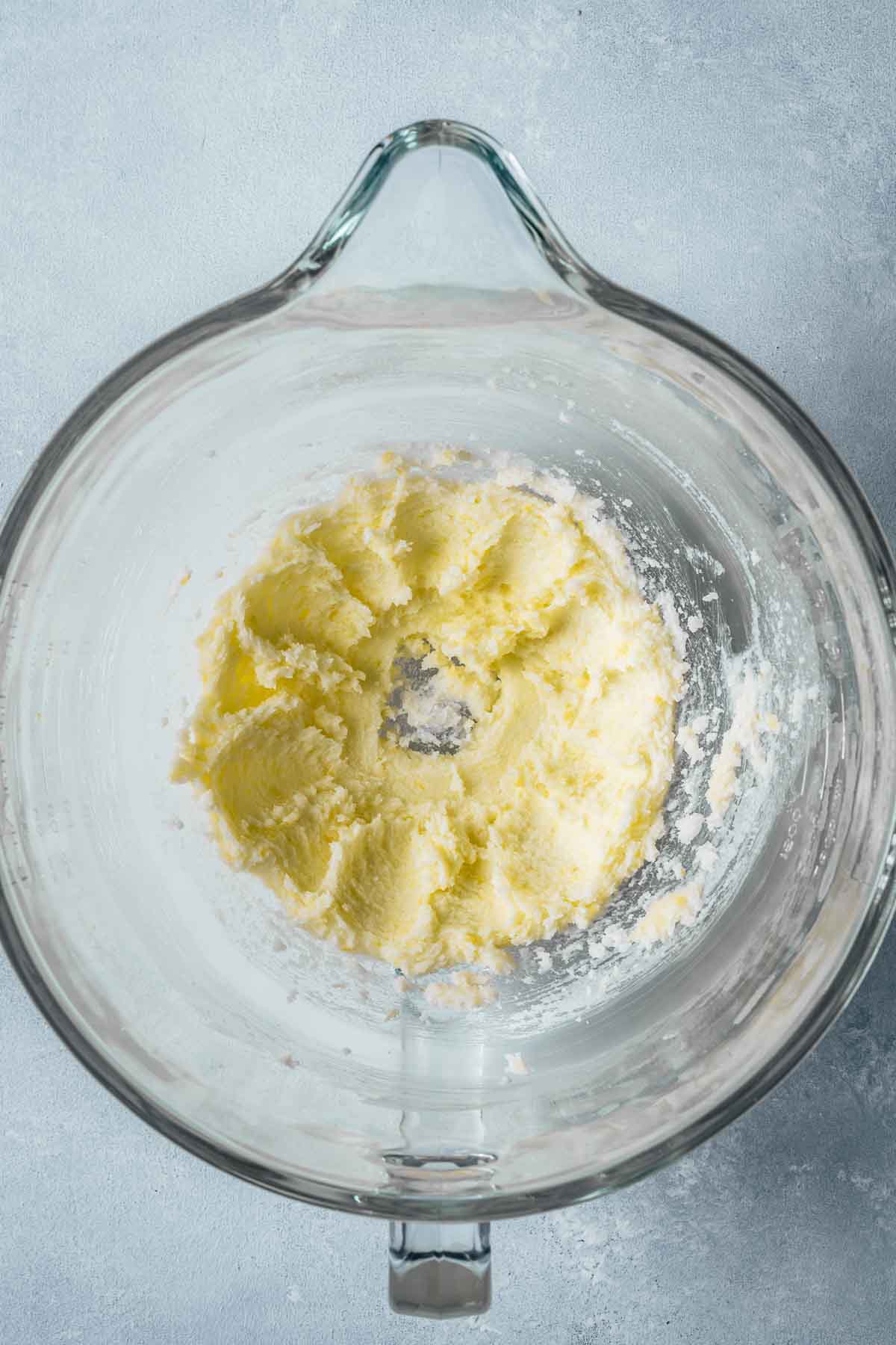 Creamed butter, sugar and lemon zest in a clear mixing bowl.