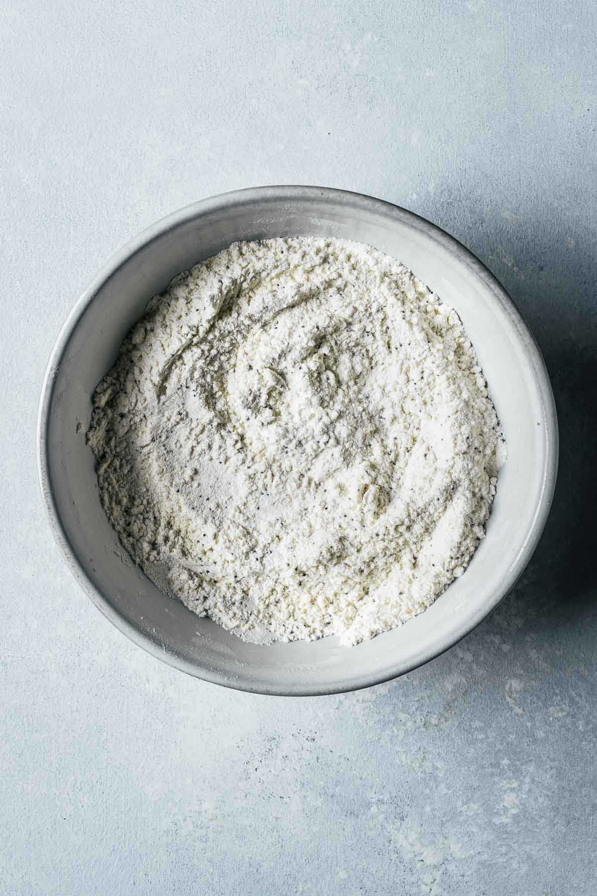 Dry ingredients for muffins in a white ceramic bowl.