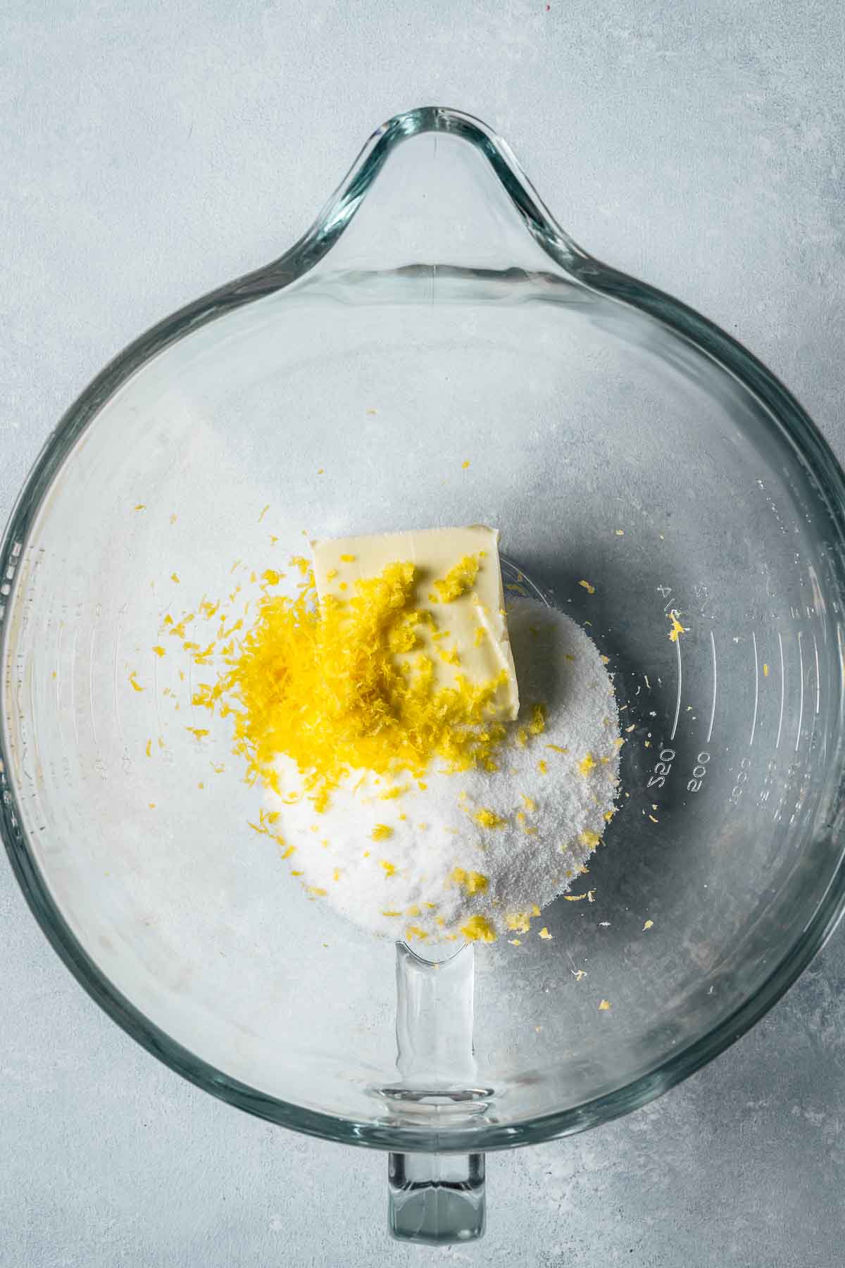 Lemon zest, butter and sugar in a glass mixing bowl.