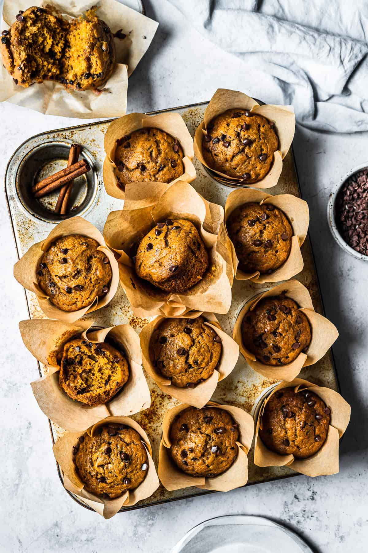 Golden brown muffins with mini chocolate chips in a muffin tin.