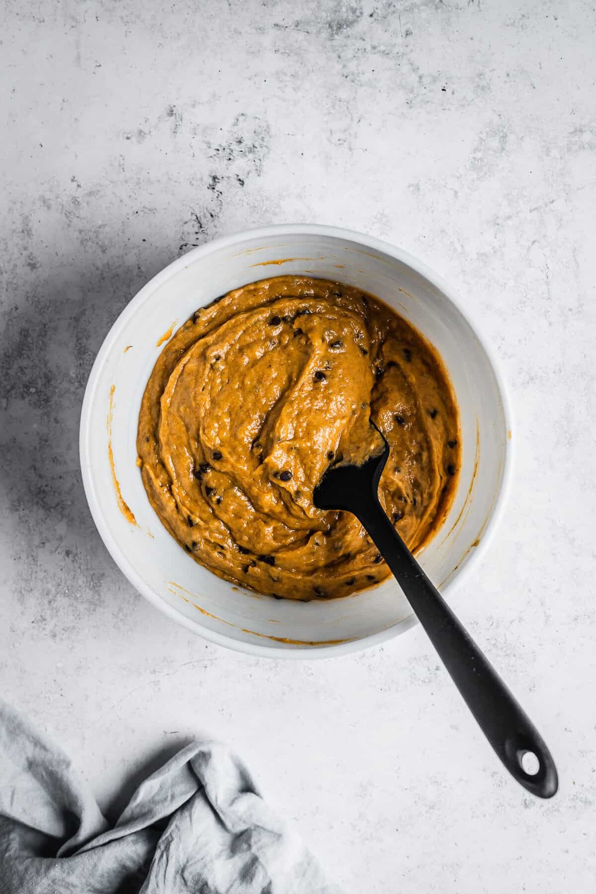 Finished muffin batter in a white glass mixing bowl.