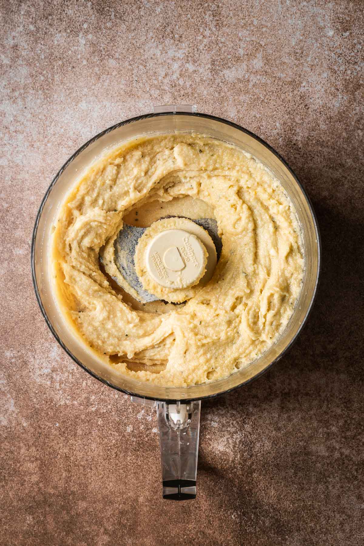 Fully mixed almond frangipane in the bowl of a food processor.