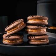 Two stacks of dulce de leche filled chocolate cookies.