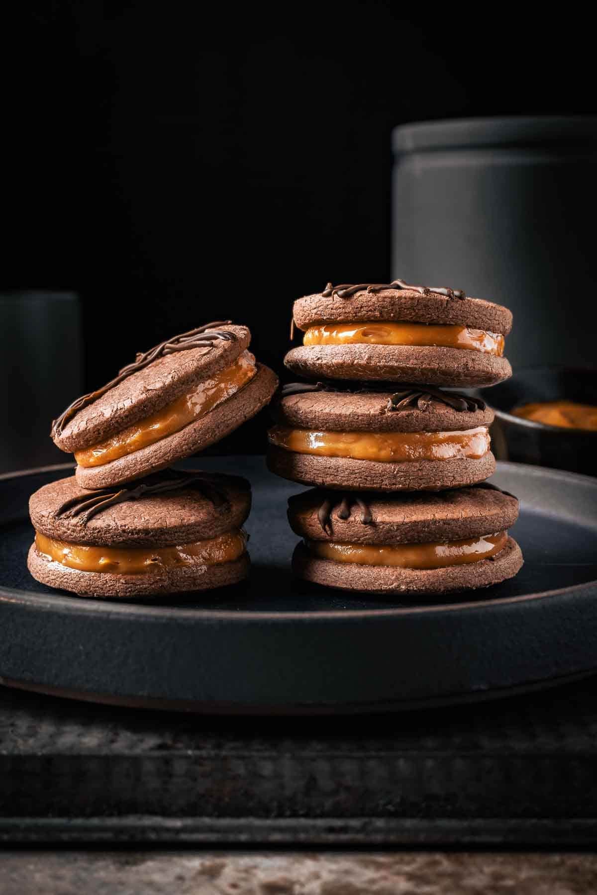 Two stacks of dulce de leche filled chocolate cookies.