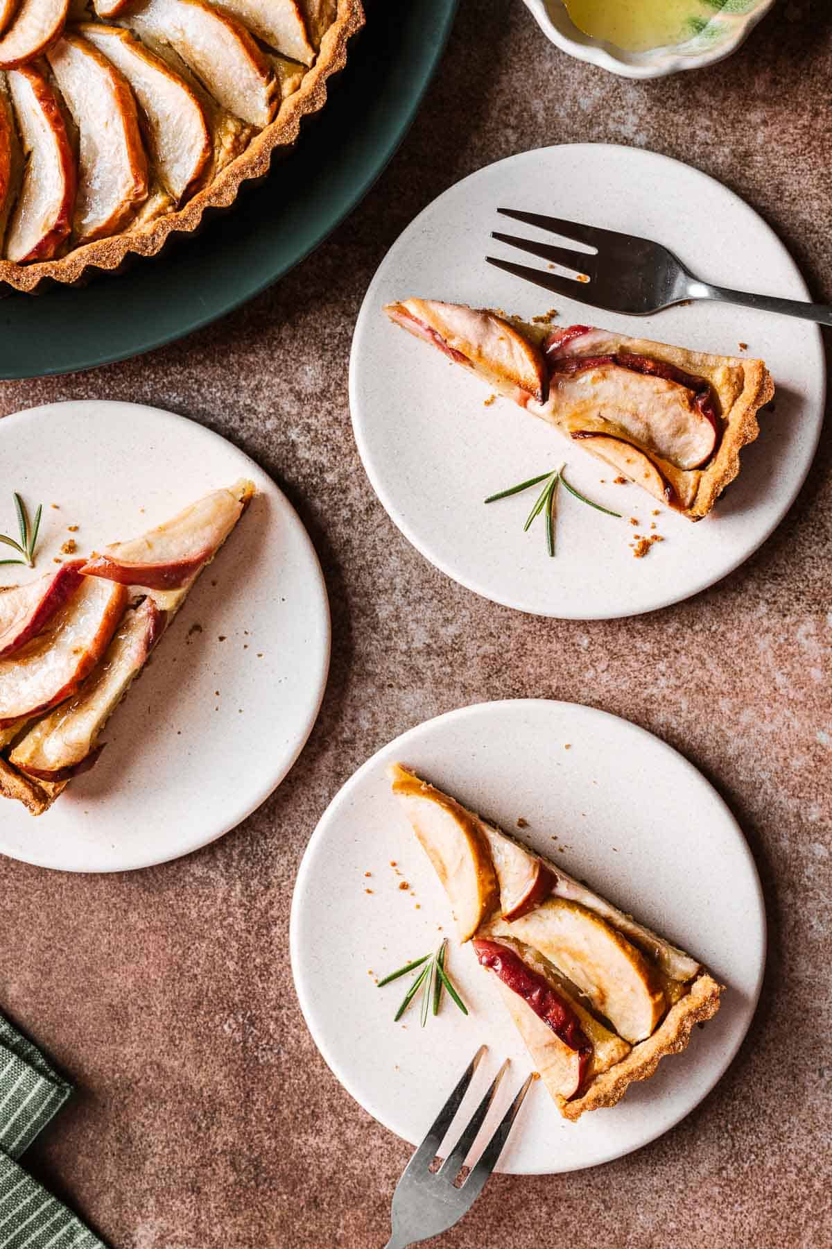 Slices of apple tart on tan plates.